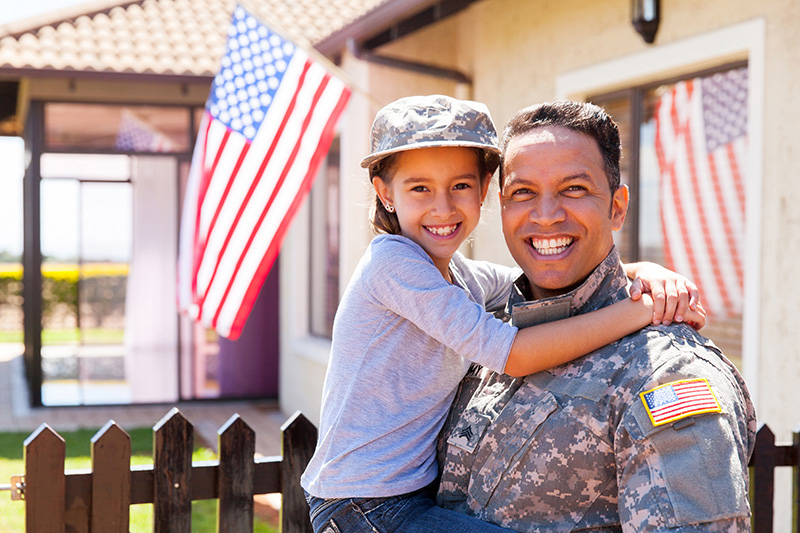 VA Loan recipient with daughter outside of new home