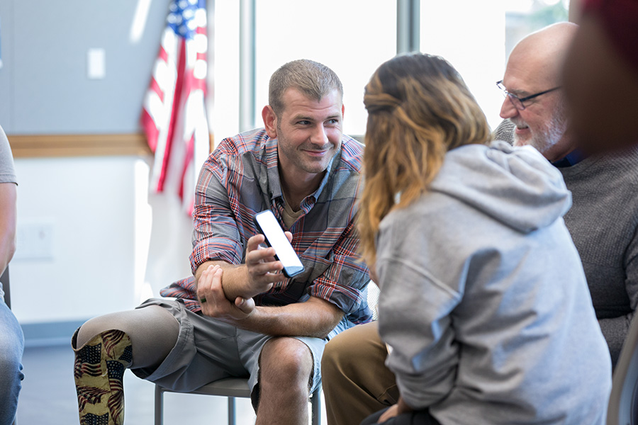 Disabled veteran shows guide to calculating your disability rating on smartphone to friends