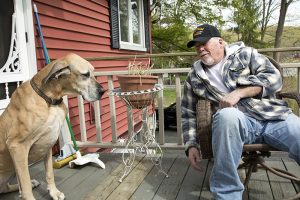 Vietnam Veteran having fun sitting in back yard with pet Great Dane