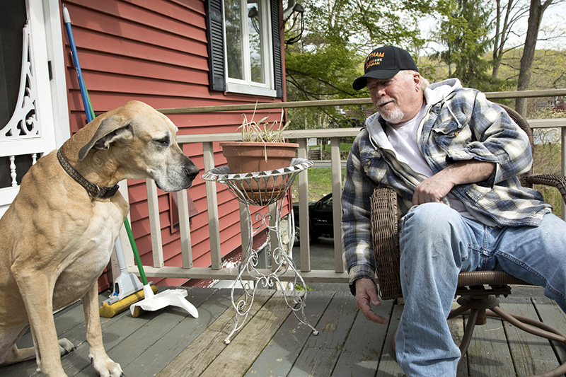 Vietnam Veteran having fun sitting in back yard with pet Great Dane