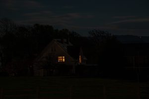A house with a single light on at night demonstrating sleep apnea concept