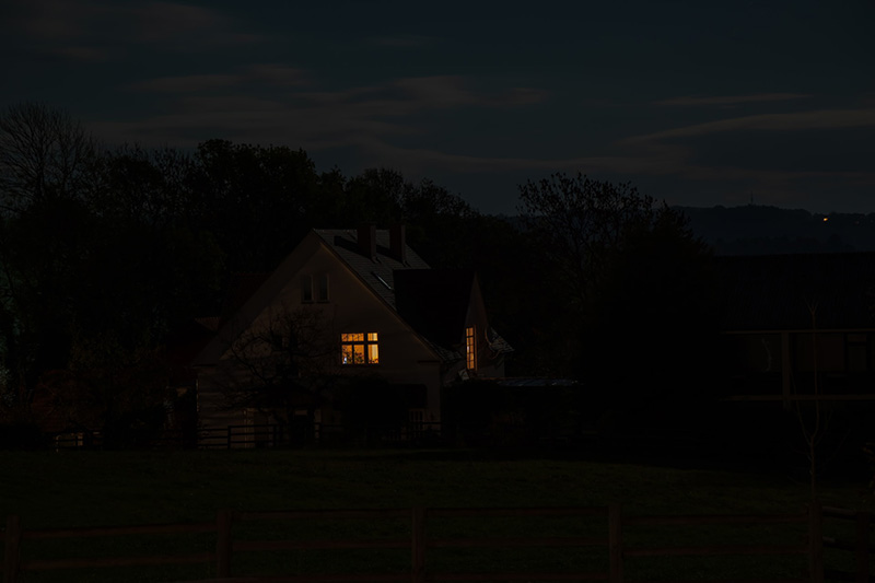 A house with a single light on at night demonstrating sleep apnea concept
