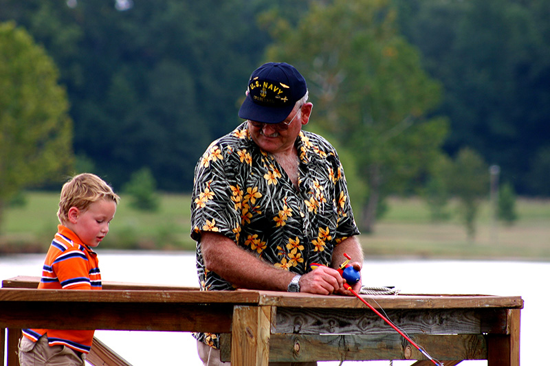 Retired veteran teaching grandson how to fish